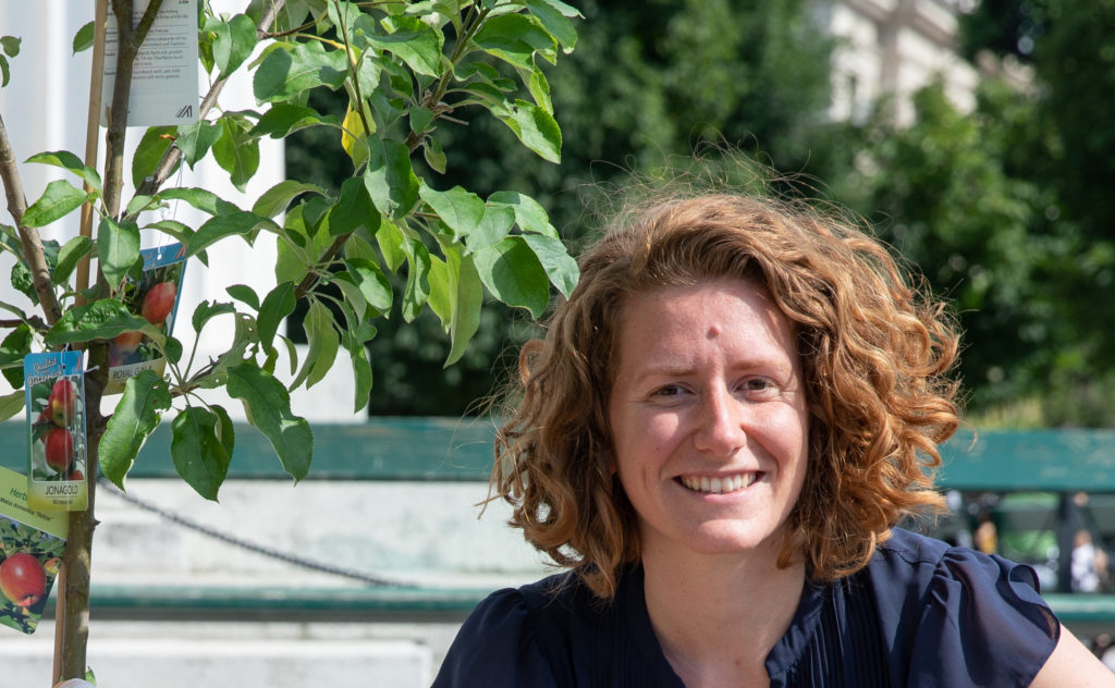 Portrait Katharina Rogenhofer, links von ihr ein junger Apfelbaum