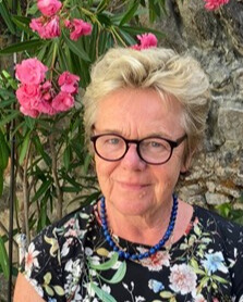 Portrait einer Frau, im Hintergrund blühende Pflanze