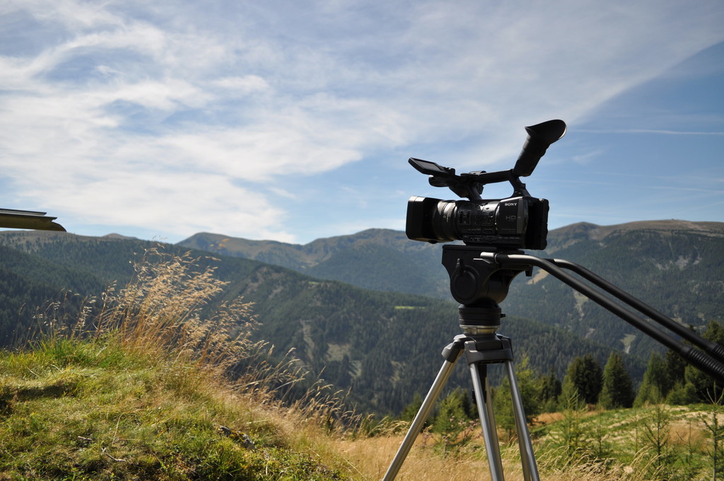Filmkamera steht in der Natur.