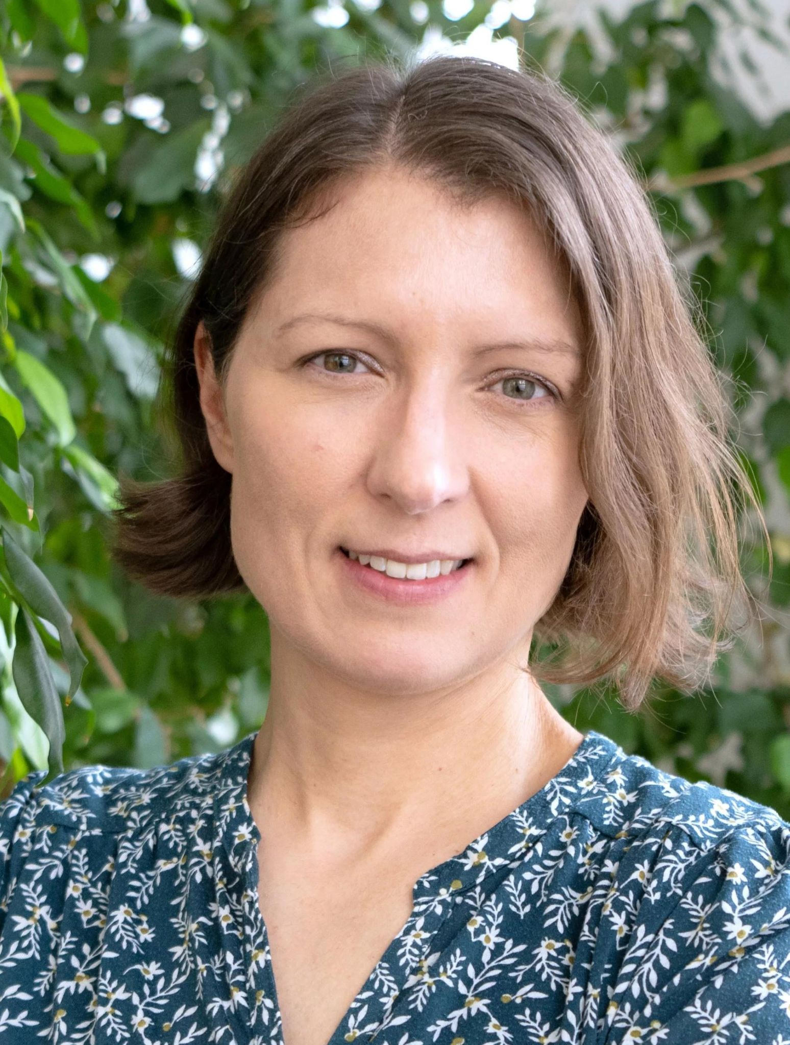 Portrait Frau, Pflanze im Hintergrund