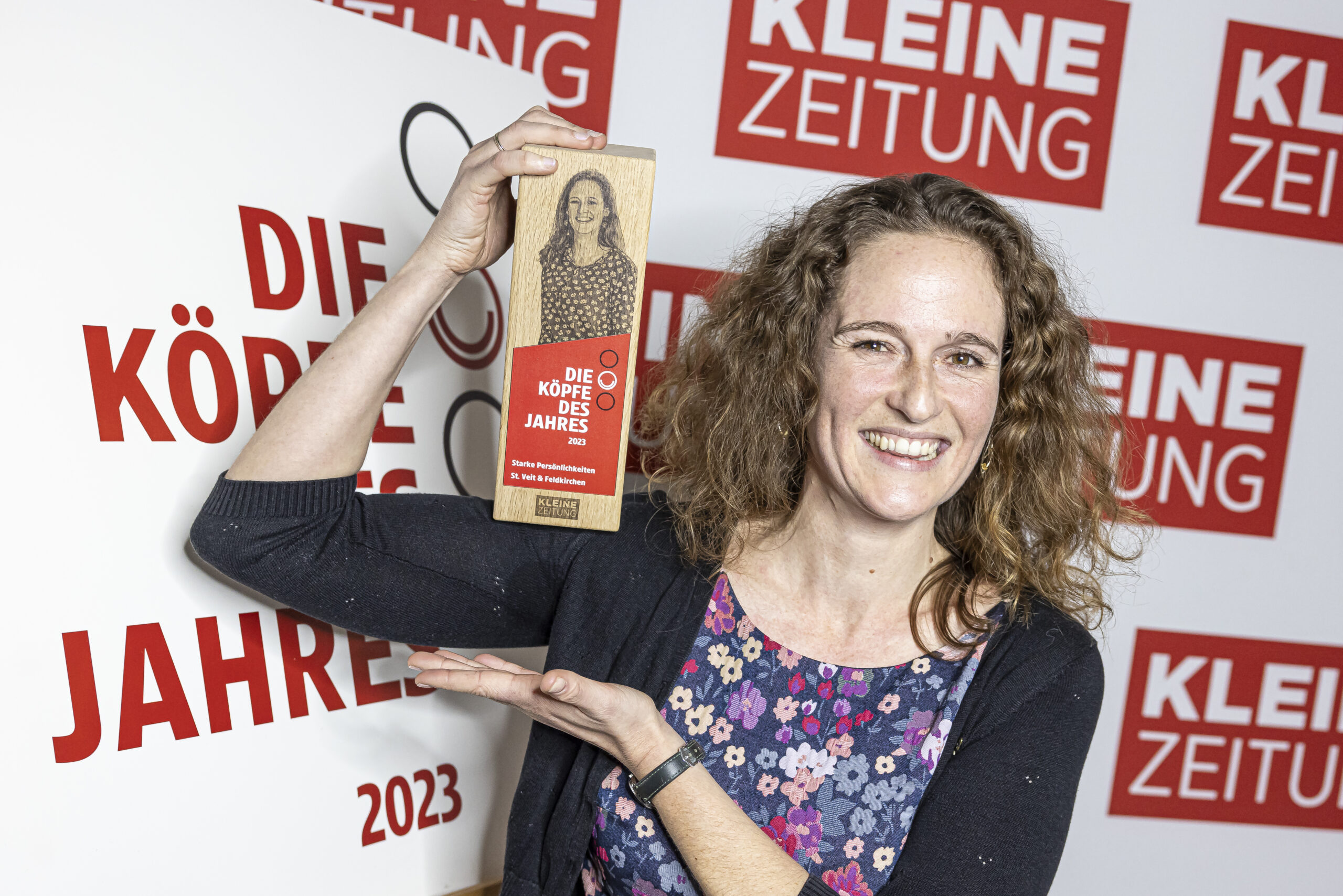 Anna-Sophie Pirtscher hält die Auszeichnung in Form einer Holzskulptur in den Händen