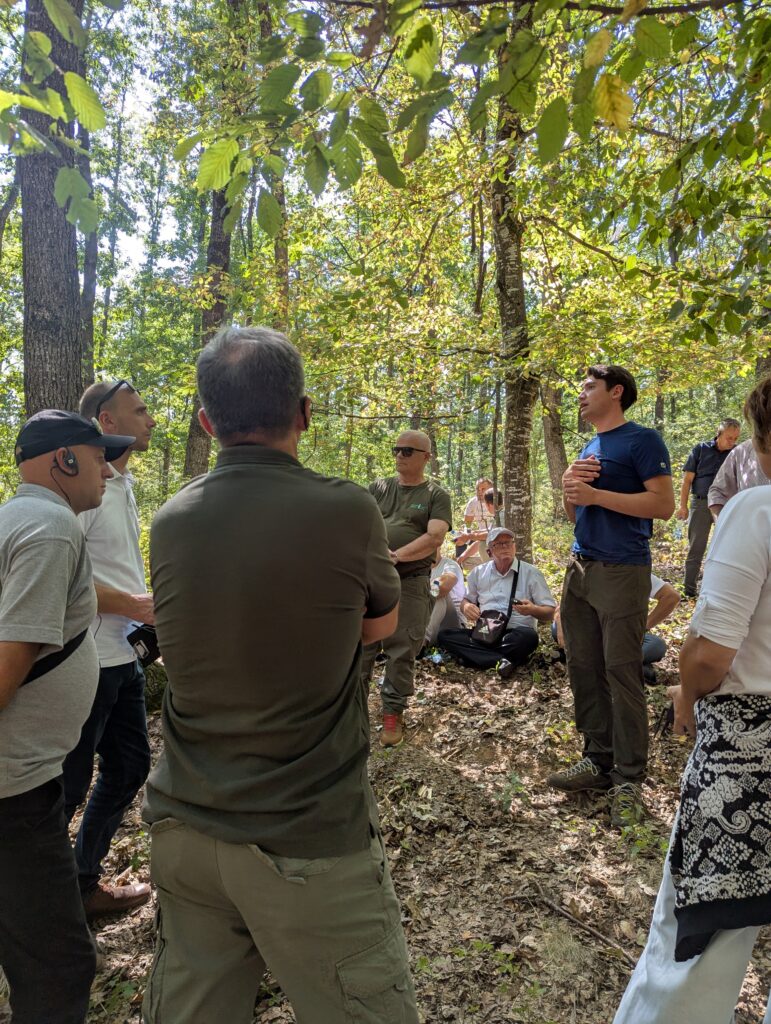 Jakob Zeiner, Förster und Trainer an der FAST Ossiach spricht im Wald zu einer Gruppe Menschen
